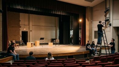 Students and crew prepare a high school theater stage for an evening rehearsal (illustrative)